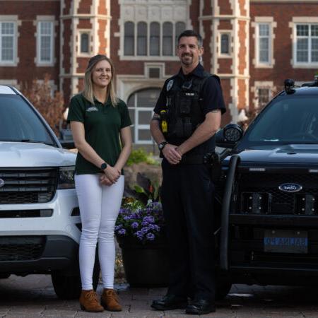 Police officer and county official in front of vehicles